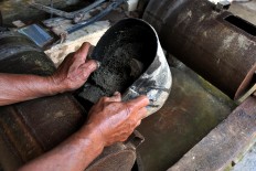 A sieve is used to filter gold particles from the soil. JP/ Magnus Hendratmo