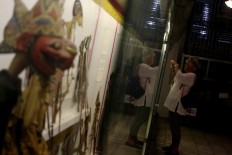 A tourist takes a photo of the puppet collection at the Radya Pustaka Museum. JP/Maksum Nur Fauzan