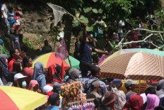 Multifunction: Some participants try to gain an advantage by using objects, such as an upside-down umbrella, to get as many apem as possible. JP/ Maksum Nur Fauzan