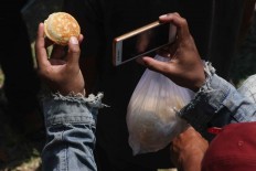Tasty memory: A participant takes a snapshot of an apem. JP/Maksum Nur Fauzan
