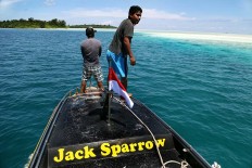 Local eye: The crew of a small boat points to coral under the sea. JP/ PJ Leo