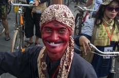 A festivalgoer from West Java dressed as Cepot or Astrajingga, one of the Wayang Golek (wooden puppet) characters in Sundanese puppetry, is all smiles. JP/Tarko Sudiarno