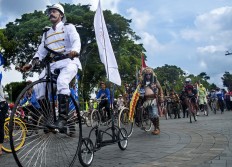 A participant rides a penny farthing, also known as a high wheel, during the Jogja Republik Onthel festival in front of the Vrederburg fortress in Yogyakarta. JP/Tarko Sudiarno