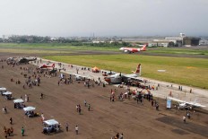 An Air Asia airplane crosses behind the tarmac used for the Bandung Air Show.  JP/Arya Dipa