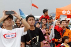 Visitors use their mobile phones to capture the moments during the aerobatic performances at the Bandung Air Show.  JP/Arya Dipa