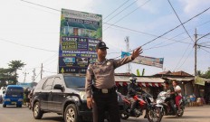 Stop there: Wahyudin directs morning traffic in Cisoka before driving in the area with his mobile library. JP/Bangkit Jaya Putra