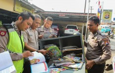Cap a book: Wahyudin (right) reads books with fellow police officers in Cisoka district before visiting schools with his mobile library. JP/Bangkit Jaya Putra