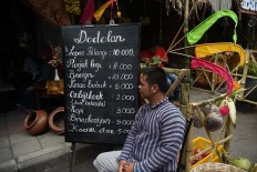A man sits in front of his food stall selling snacks during the 2017 festival. JP/Aman Rochman