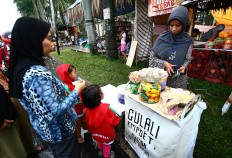 A mother and her two children buy some candy at the 2011 Malang Tempo Doeloe Festival on Jl. Ijen, Malang, East Java, on May 20, 2011. JP/Aman Rochman