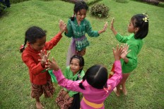 Riddle me this: Four girls play a traditional guessing game during the Ajar Pusaka Budaya event. JP/ Aman Rochman