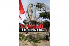 Seizing the moment: Swiss tourist Lina (right) takes a picture of her friend, Naja, posing in front of the Zero Kilometer Monument on Weh Island. JP/ PJ Leo