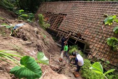 Members of the Kampung Cyber community help clean up debris at a house in Bantul regency on Dec. 3, 2017. JP/Aditya Sagita