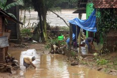 Villagers clean up mud and debris from their houses along the banks of the Oya River in Siluk village, Bantul regency. JP/Aditya Sagita