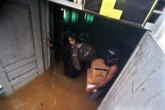 A teacher and a student move important files from the inundated SMKN 1 vocational school Tanjungsari in Gunungkidul regency. JP/Aditya Sagita