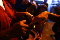 Children dip their fingers into torch oil. The torches are used to light the Kauman Grand Mosque yard for the whole week when the gamelan is played. JP/ Wienda Parwitasari