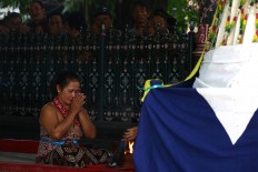 A female courtier takes a bow prior to the marching of eight gunungan (mound of rice with side dishes) at the north courtyard of Yogyakarta Palace on Dec. 1. JP/ Wienda Parwitasari