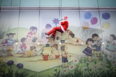 A man dressed as a Santa Claus descends from the roof of the Pediatric Clinic in Ljubljana, on December 19, 2017. Men dressed as a Santa Claus descended from the roof of Pediatric Clinic to entertain the children and bring them presents. AFP/Jure Makovec