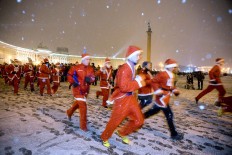 Participants wear Santa Claus costumes as hey take part in the Christmas race at Dvortsovaya square in Saint Petersburg, on December 23, 2017. AFP/Olga Maltseva