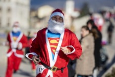 A man dressed as Santa Claus with Superman t-shirt takes part in the traditional New Year's Santa Claus race in Skopje, on December 24, 2017. AFP/Robert Atanasovski