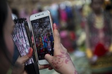 A family member captures the proud moment with her mobile phone. Antara/Rosa Panggabean
