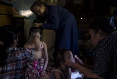 Family members of girls participating in the Karia ceremony are busy putting on makeup. Antara/Rosa Panggabean
