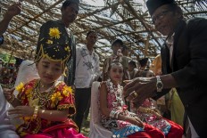 The girls take part in the landa futa procession in which a religious leader will grease turmeric in the girls’ forehead and feet and pray for their future. Antara/Rosa Panggabean