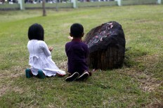 Two children pray at the mass burial site. JP/Hotli Simanjuntak