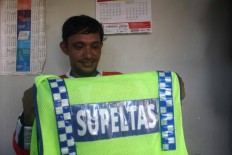 He folds up his Supeltas (volunteer traffic warden) vest. JP/Maksum Nur Fauzan