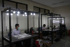 Work in progress: Three employees digitize old newspapers. JP/Maksum Nur Fauzan.