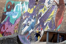 A picture taken on December 16, 2017 shows children skateboarding next to graffiti murals in the Jordanian capital Amman. A tiny group of graffiti artists are on a mission -- daubing flowers, faces and patterns across the capital Amman to bring more colour to the lives of its four million inhabitants.
In a conservative society like Jordan's, the graffiti artists have constantly had to challenge convention to carve out a niche for their works, though still with limits as they steer away from politics and religion. AFP/Khalil Mazraawi  
