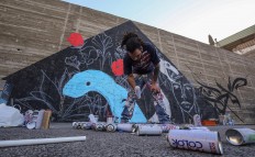 Suhaib Attar, a 25-year-old graffiti artist and student, picks up a canister of spray paint as he draws a mural on a wall in the capital Jordanian Amman on December 16, 2017. A tiny group of graffiti artists are on a mission -- daubing flowers, faces and patterns across the capital Amman to bring more colour to the lives of its four million inhabitants.
In a conservative society like Jordan's, the graffiti artists have constantly had to challenge convention to carve out a niche for their works, though still with limits as they steer away from politics and religion. AFP/Khalil Mazraawi  