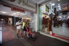 A family strolls down a sidewalk on Malioboro, which is usually occupied by street vendors. JP/Boy T. Harjanto