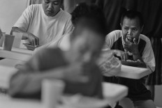 Patients eat lunch in the cafeteria. Antara/Hafidz Mubarak