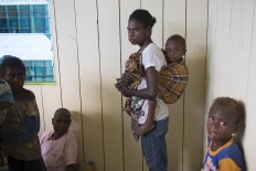 A Papuan woman and their children wait for medical treatment at local clinic at Ayam village in Asmat district in Indonesia's easternmost Papua province on January 26, 2018.
Some 800 children have been sickened by a measles-and-malnutrition outbreak in Indonesia's remote Papua province, officials said January 25, with as many as 100 people, mostly toddlers, feared to have been killed in the outbreak. AFP/ Bay Ismoyo