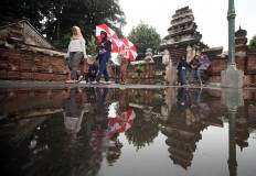 Visitors are using umbrellas to cover themselves from the rain. JP/Boy T. Harjanto