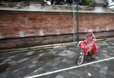 A girl rides her bike in the mosque's compound after performing the midday prayer. JP/Boy T. Harjanto