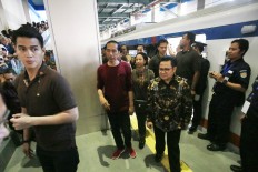 Wearing a collarless shirt, President Joko “Jokowi” Widodo (center) and National Awakening Party chairman Muhaimin Iskandar (right) inspects the airport train after inauguration the new service connecting Soekarno-Hatta International Airport in Tangerang, Banten, with Jakarta’s inner city on Tuesday, January. 2. JP/Dhoni Setiawan
