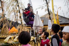 Three young men play on the giant swing the day after the ceremony. JP/Anggara Mahendra