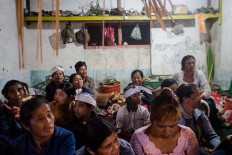 Villagers take shelter from rain and thunder inside a temple. JP/Anggara Mahendra