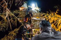 Villagers take down all the offerings following the end of the ceremony. JP/Anggara Mahendra