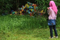 A girl photographs an art installation in the backyard of the Mugi Dance studio during the festival. JP/Magnus Hendratmo