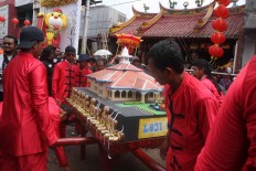 Home sweet home: Men carry a miniature Loji Gandrung decorated with kue keranjang (basket cake).   JP/ Maksum Nur Fauzan