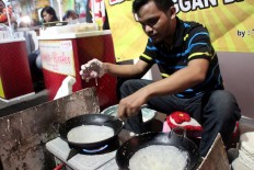 Takim demonstrates his skill in making lunpia (spring roll) skin at the night market. Semarang is famous for its lunpia. JP/Suherdjoko