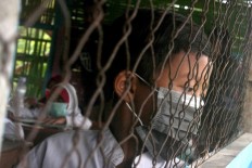 A boy looks outside the class window while wearing his surgical mask. JP/Maksum Nur Fauzan