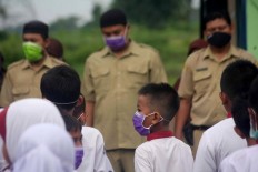 Teachers and students all wear surgical masks during the hoisting of the flag. JP/Maksum Nur Fauzan