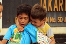 Finding happiness: Two children make the most of their circumstances. JP/ Rifky Dewandaru