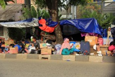 Whatever means necessary: Refugees use temporary shelter to seek relief from the blistering sun. JP/ Rifky Dewandaru