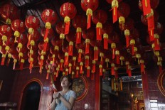 New Year spirit: A woman prays in the Dharma Bakti vihara in West Jakarta on Wednesday, February 14. The oldest Buddhist house of worship in the city, built in 1650, is decorated with red lanterns to welcome Imlek.JP/Ricky Yudhistira
