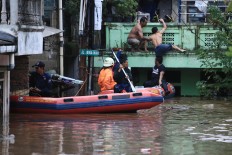 Search and rescue: Officials evacuate a resident from a flooded area in Rawajati, South Jakarta,on Monday, February 5. Heavy downpours that have struck Bogor and the mountainous Puncak area in West Java since Sunday night have caused flooding in areas along the Ciliwung river in Jakarta. JP/Dhoni Setiawan