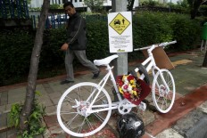 A pedestrian passes a memorial erected by the Rocketers cycling community dedicated to Raden Sandy Syafiek, a cyclist who died after being hit by a car on Saturday, February 10, on Jl Gatot Subroto in South Jakarta. The memorial is a reminder to road users to respect each other. JP/Wendra Ajistyatama